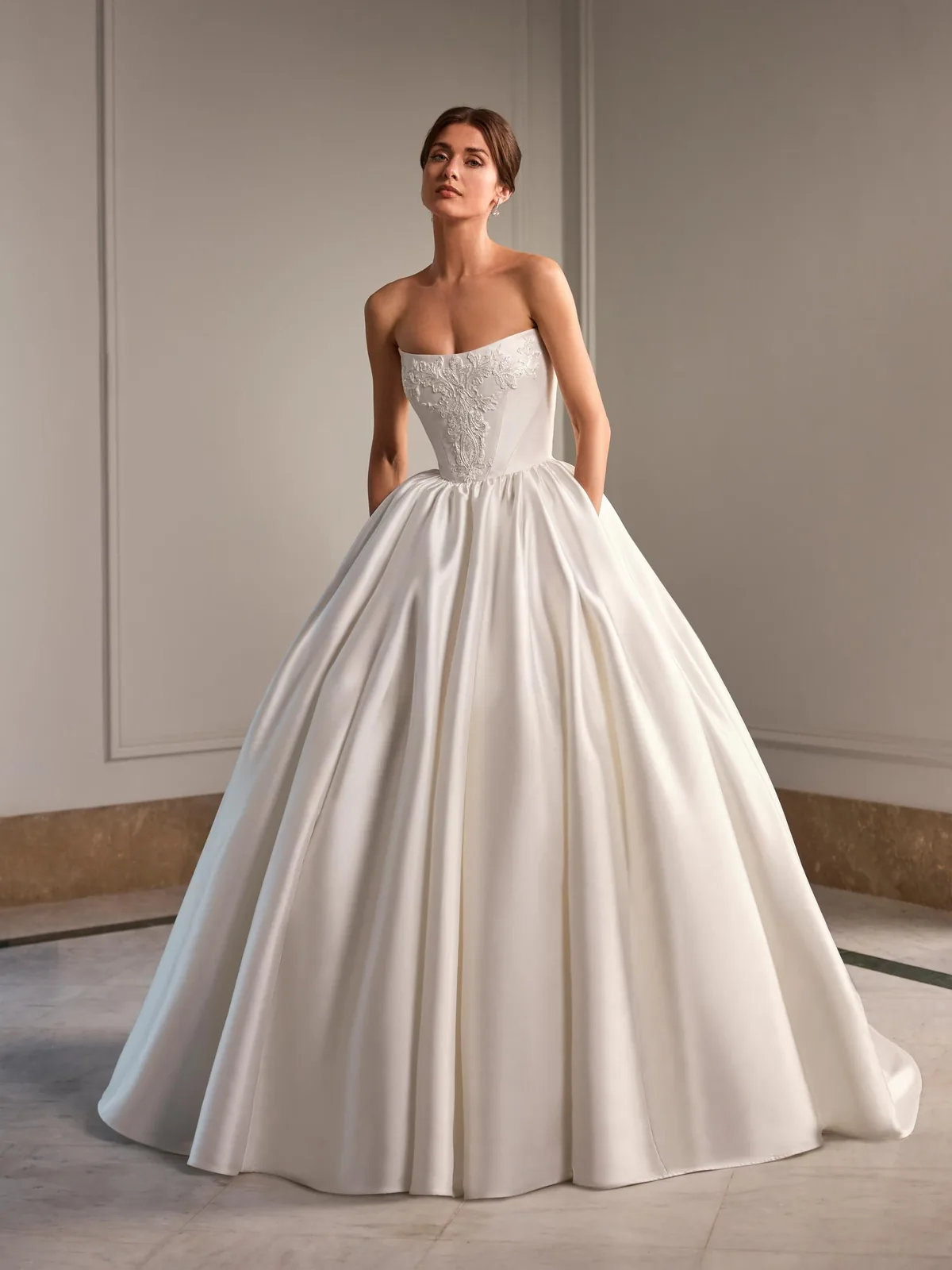 Soulmy by House of St. Patrick, a strapless satin ball gown with an embroidered corset bodice and pockets